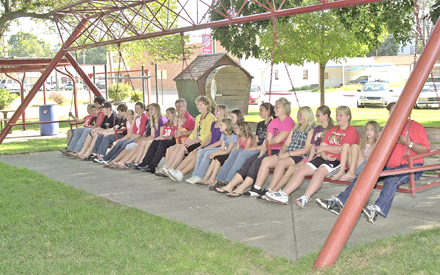 Above: U.S. Senator Mike Johanns takes a moment during his visit to Hebron Tuesday morning to swing with 4-H students on the World’s Largest Porch Swing. 